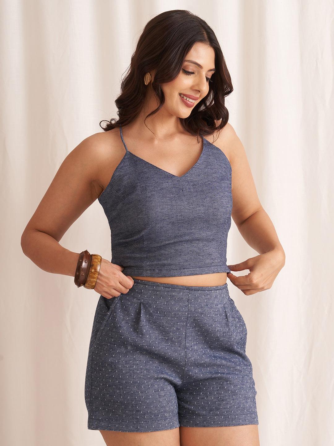 Woman wearing a RERASA blue crop top and shorts set against a white background