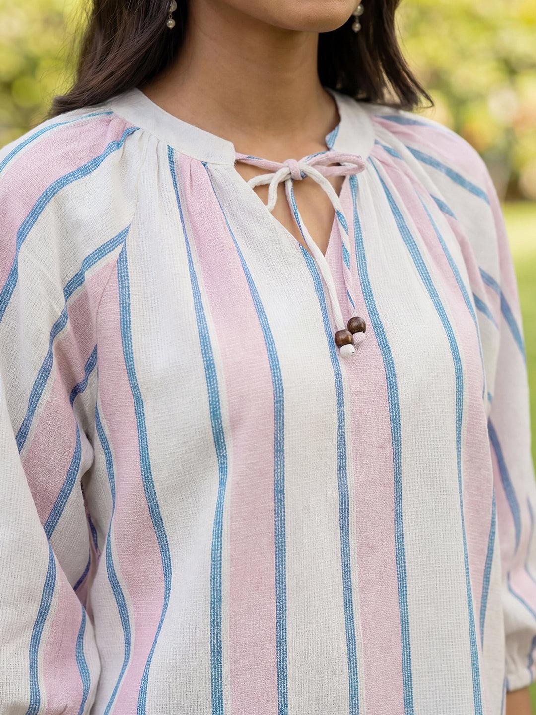 Close-up of a person wearing a pink, blue, striped  top