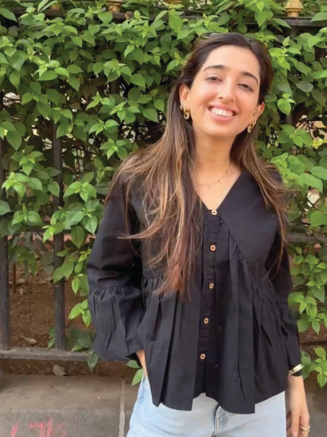 Woman wearing a black blouse with ruffled sleeves by Rerasa