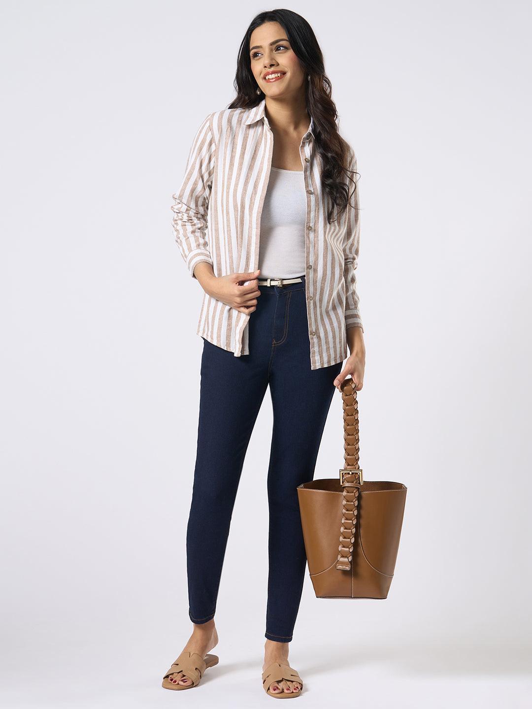 Woman wearing a Rerasa beige and white striped shirt against a plain 