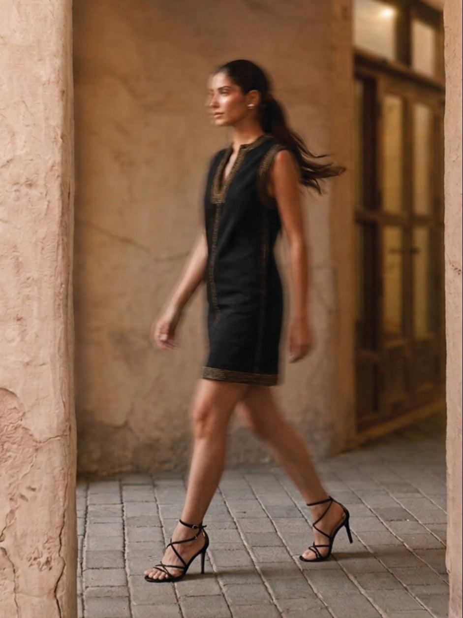 Woman wearing a black dress with brown trim 