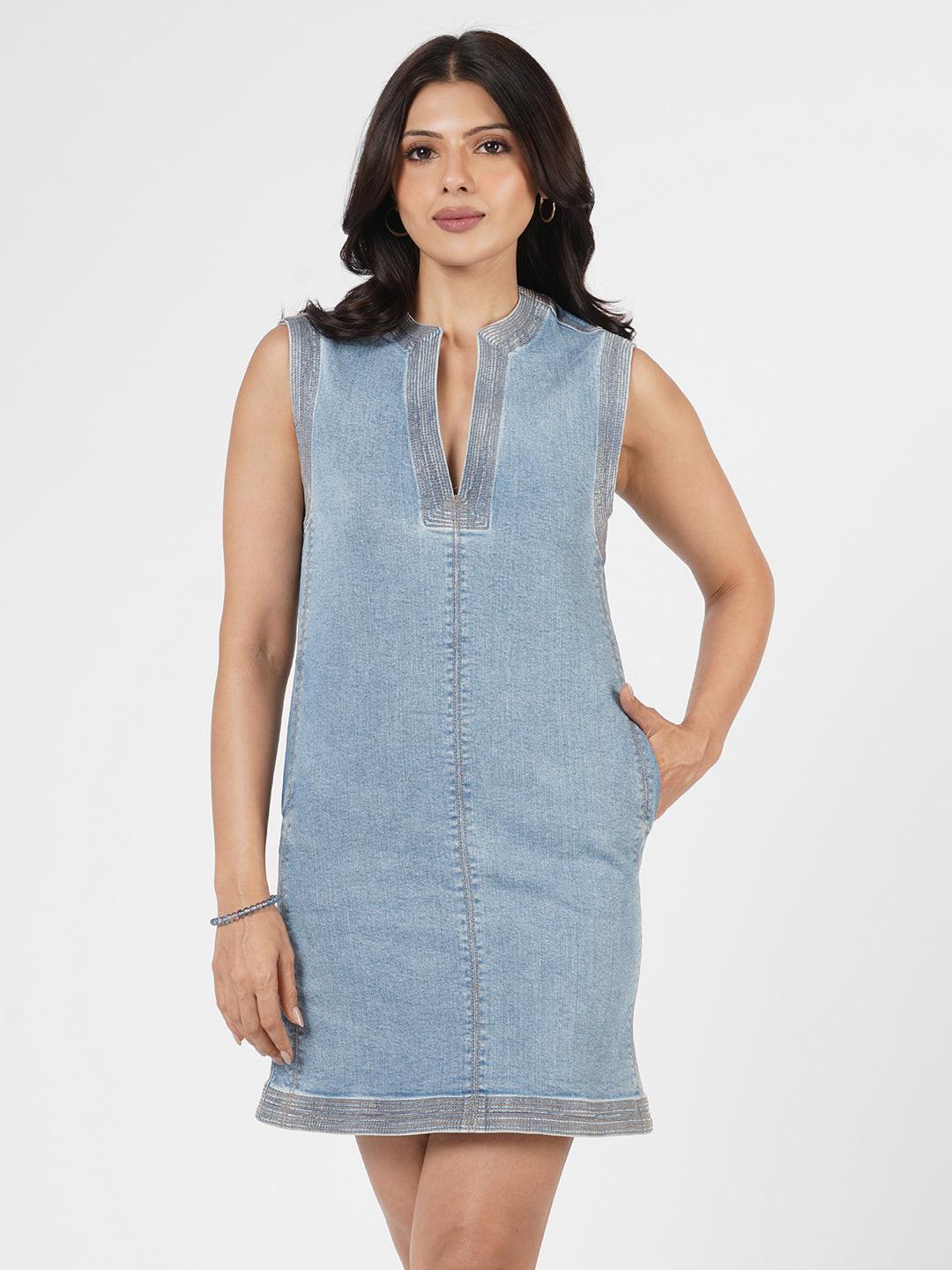 Woman wearing a indigo dress with brown trim 