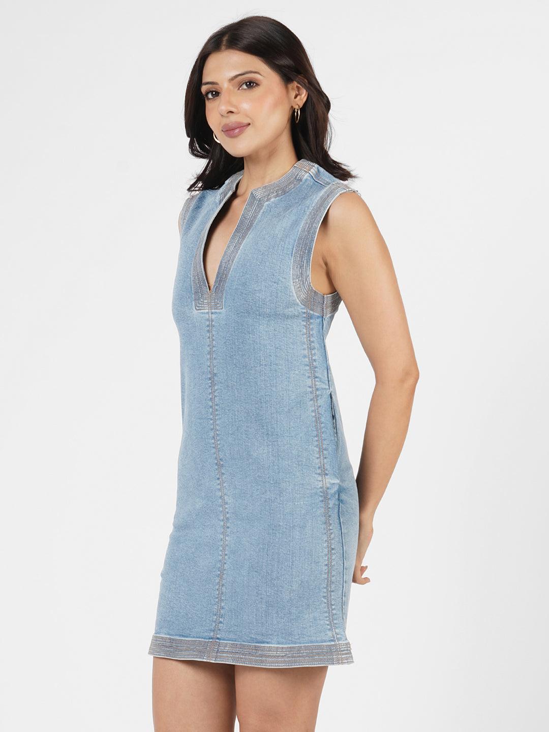 Woman wearing a indigo dress with brown trim 