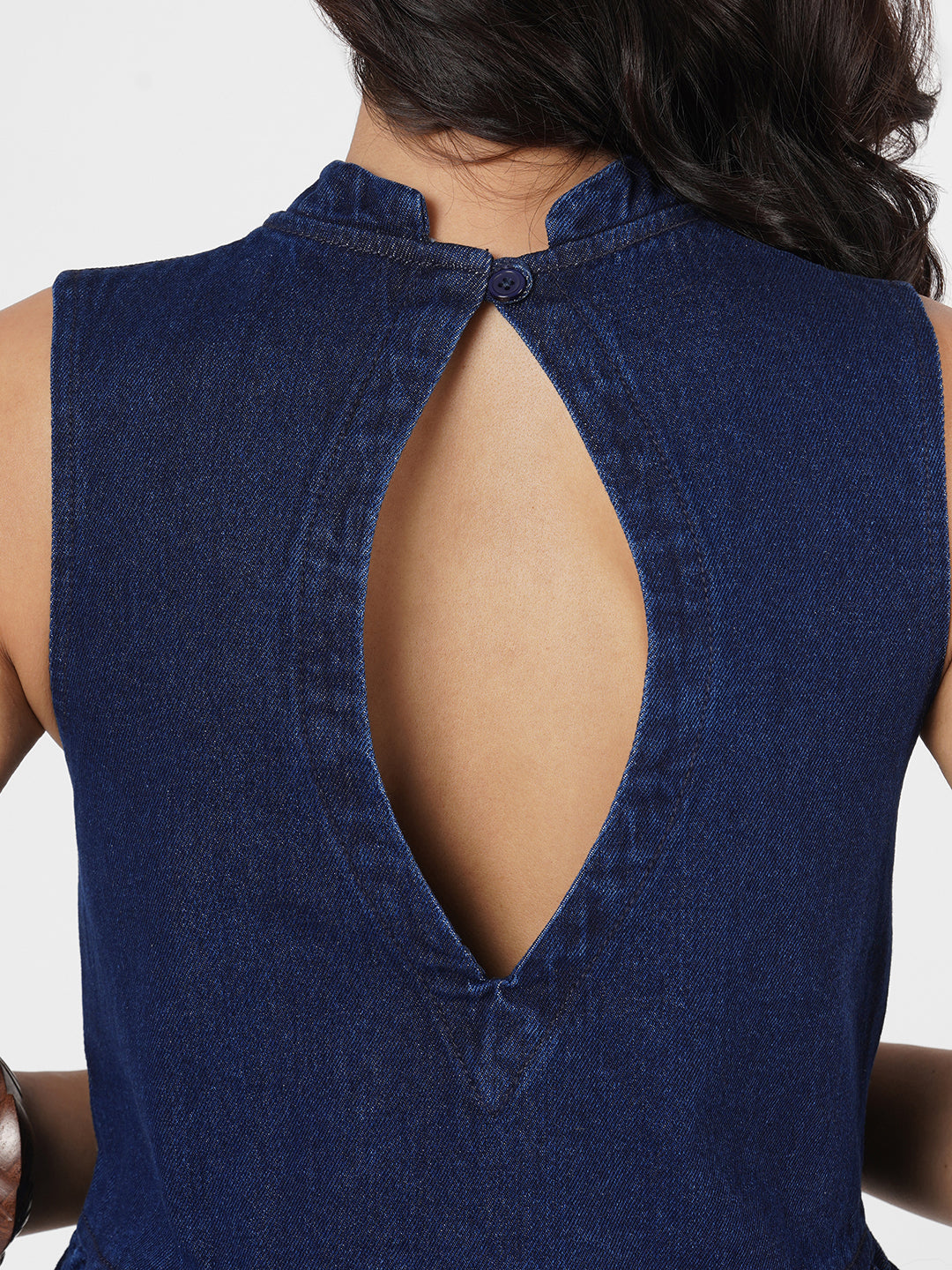 Woman wearing a navy blue sleeveless peplum top by Rerasa