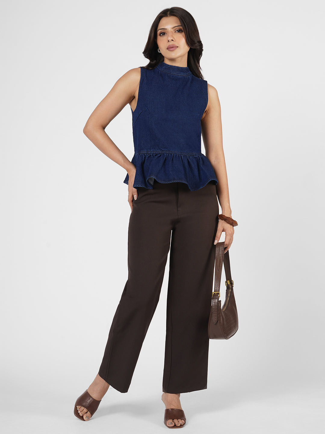 Woman wearing a navy blue sleeveless peplum top by Rerasa
