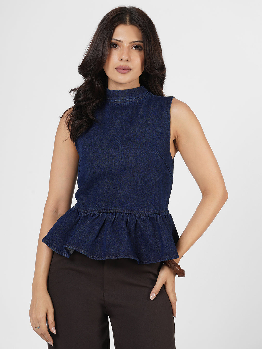 Woman wearing a navy blue sleeveless peplum top by Rerasa