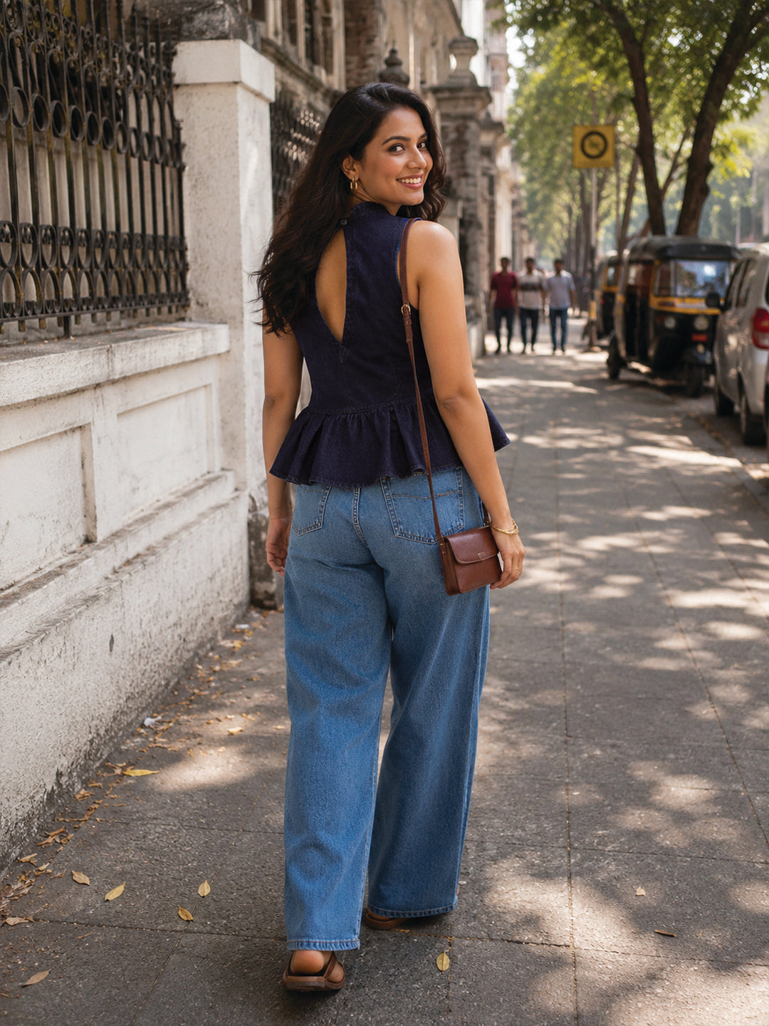 Woman wearing a navy blue sleeveless peplum top by Rerasa
