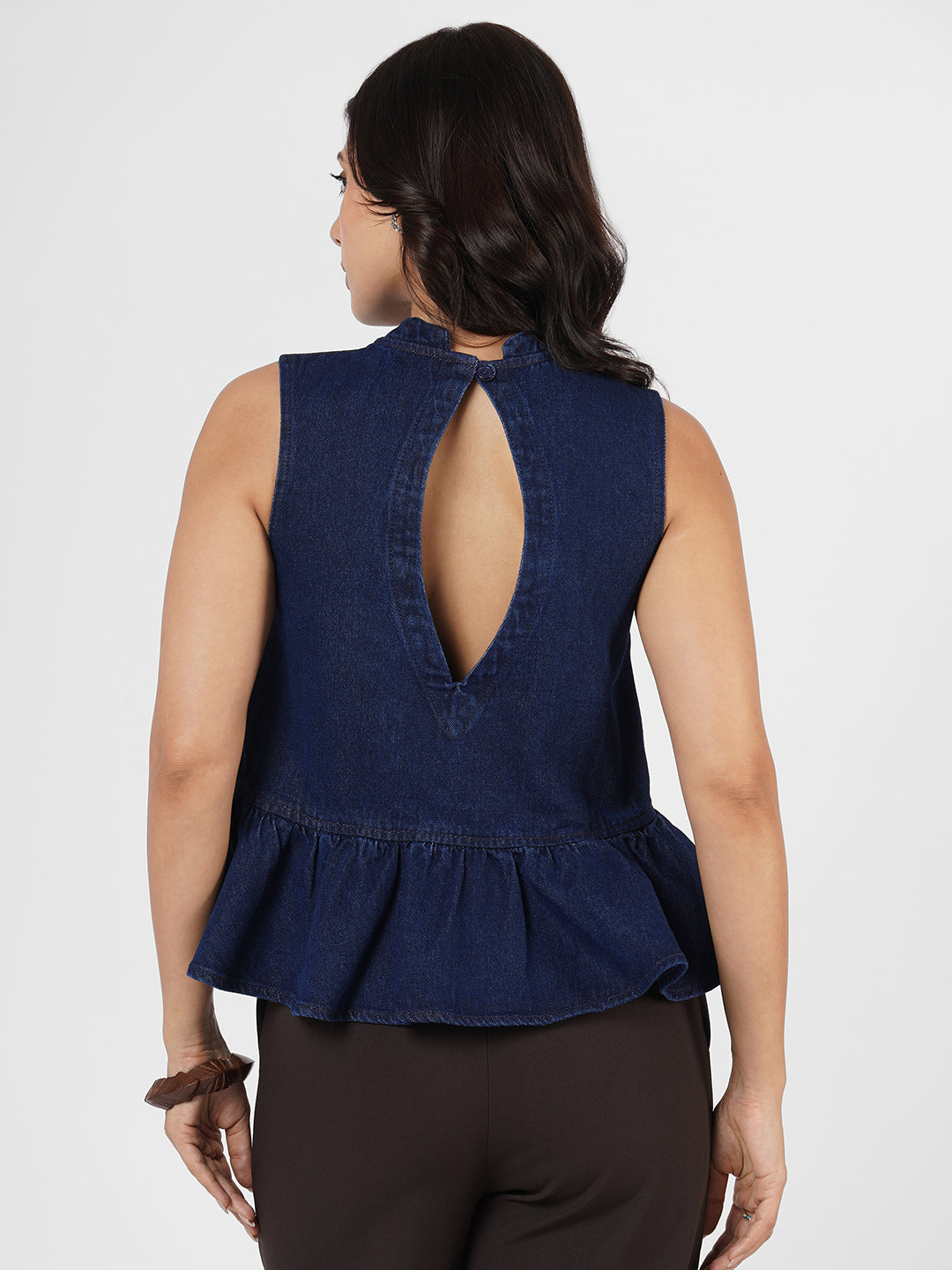 Woman wearing a navy blue sleeveless peplum top by Rerasa