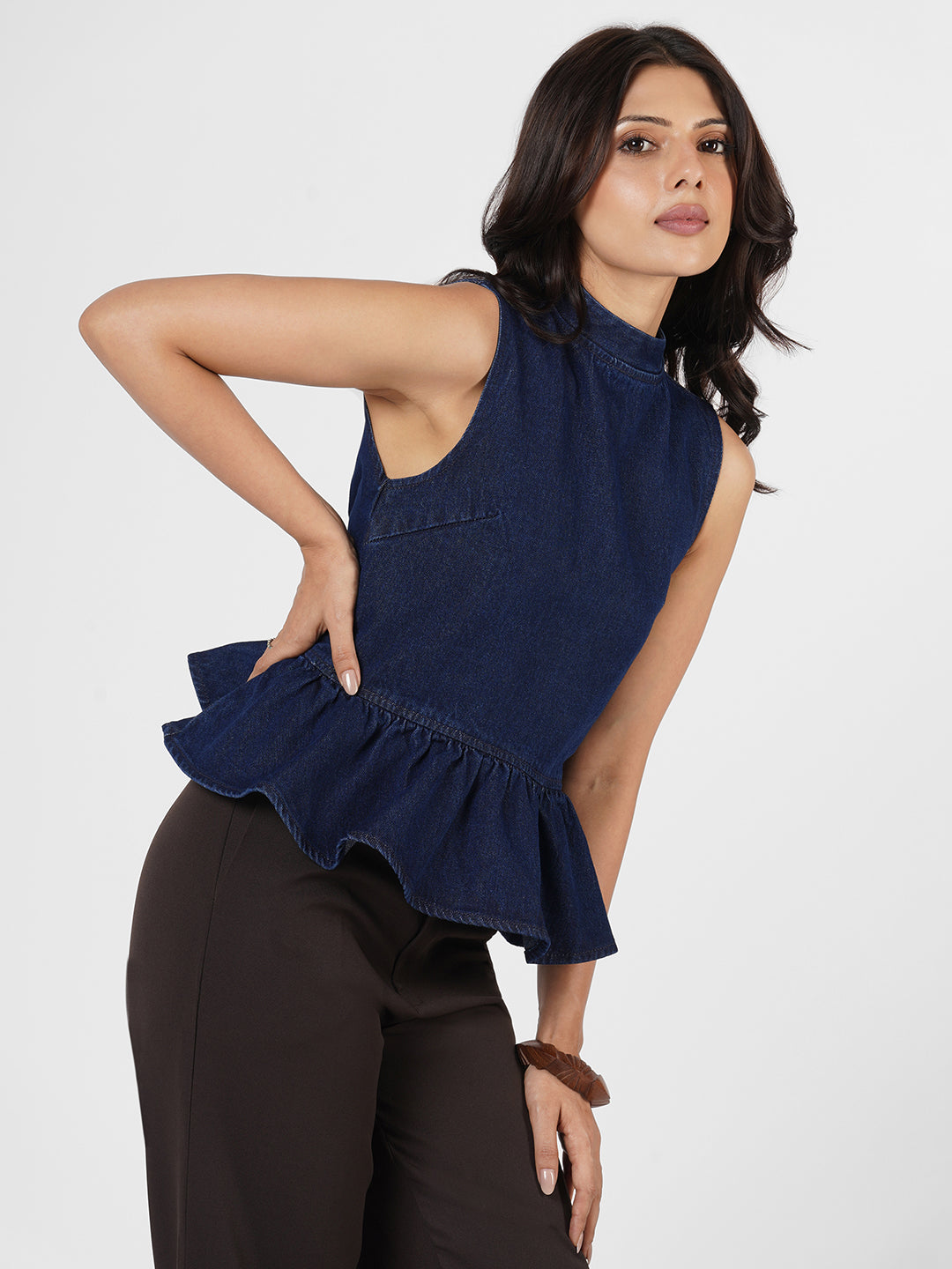 Woman wearing a navy blue sleeveless peplum top by Rerasa