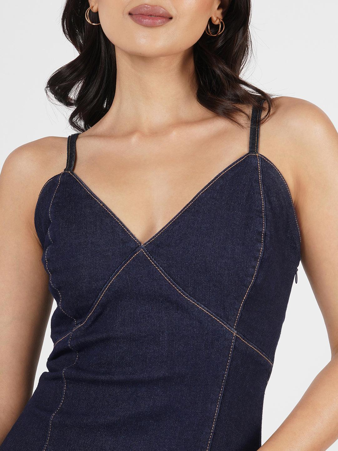 Woman wearing a navy blue spaghetti denim dress 