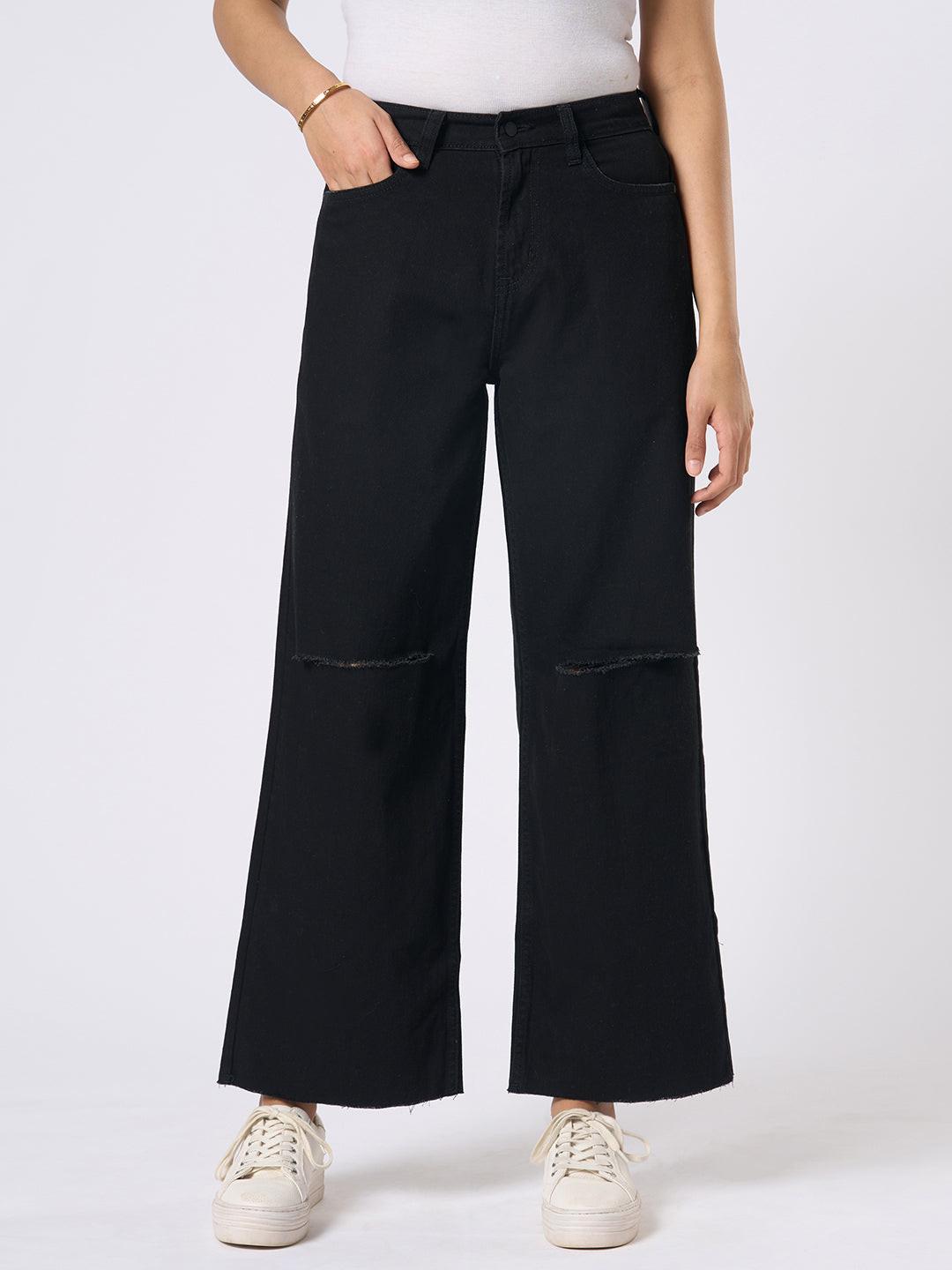 Person wearing black wide-leg jeans with distressed details by Rerasa