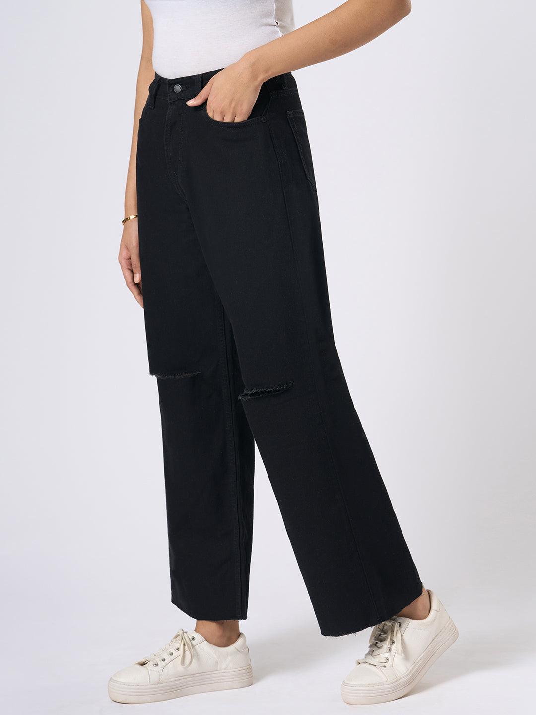 Person wearing black wide-leg jeans with distressed details by Rerasa