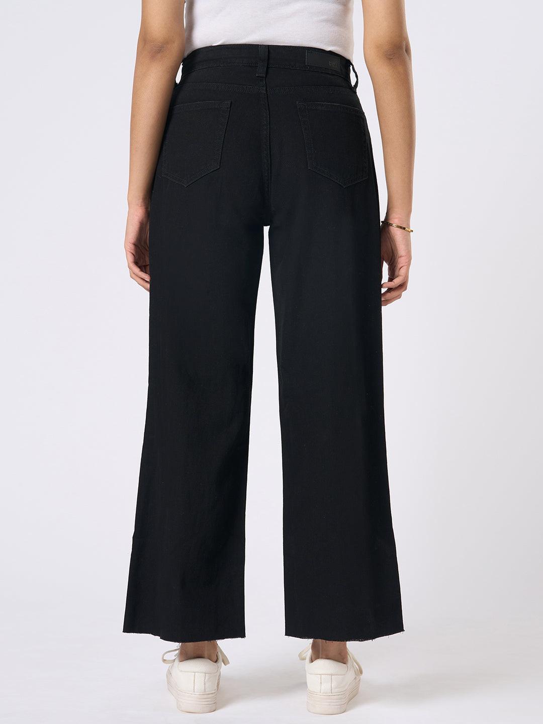 Person wearing black wide-leg jeans with distressed details by Rerasa