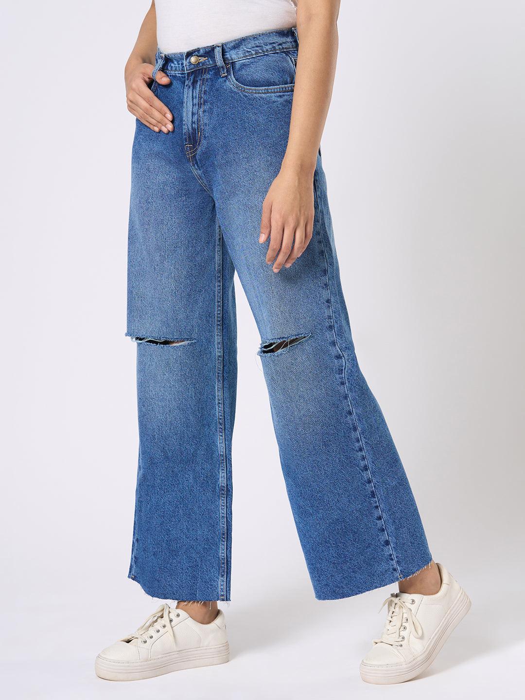 Person wearing blue wide-leg jeans with distressed details by Rerasa