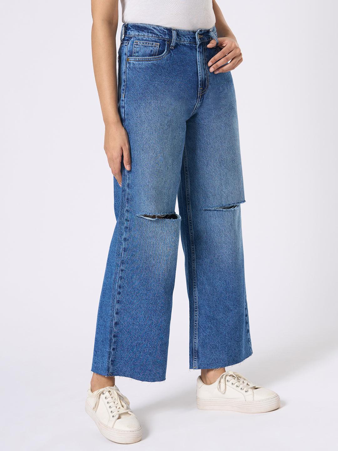 Person wearing blue wide-leg jeans with distressed details by Rerasa