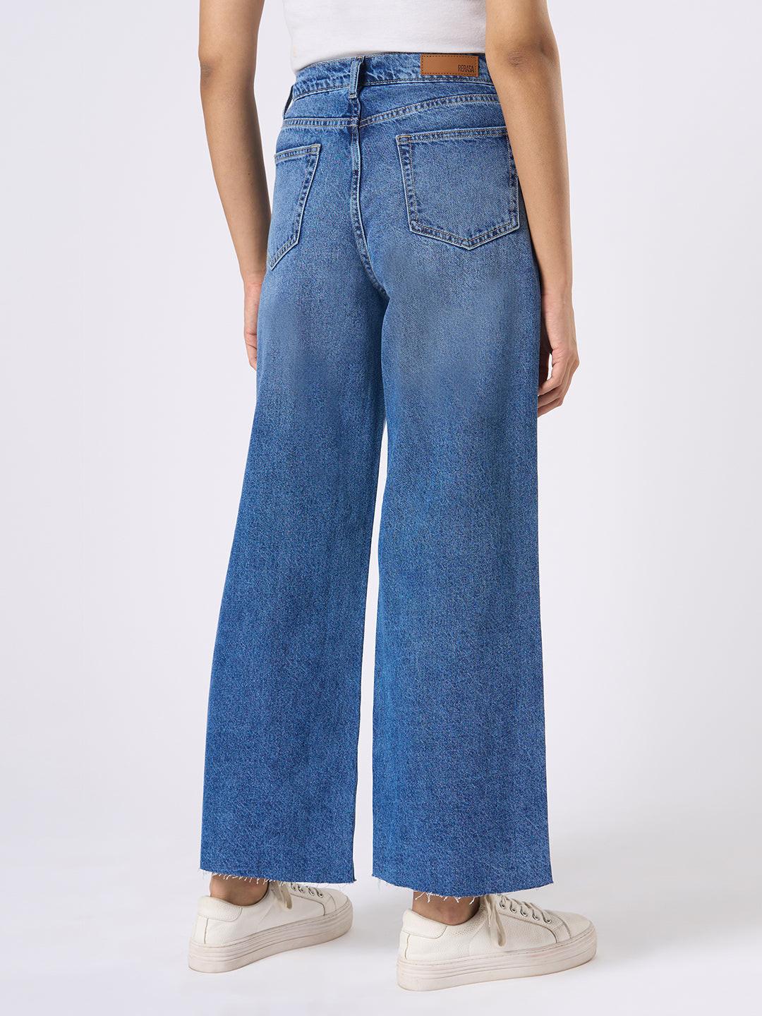 Person wearing blue wide-leg jeans with distressed details by Rerasa